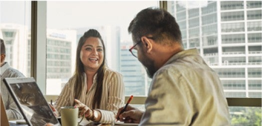 Dos personas trabajan juntas en una reunión.