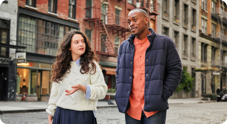 Two friends talking on city street