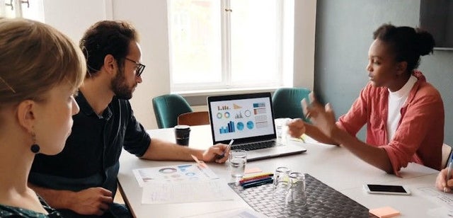 Illustration zweier Personen, die zusammen am Laptop arbeiten