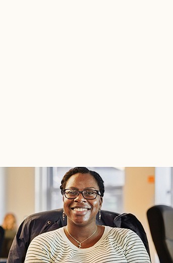 photograph of a smiling woman sitting down facing the camera