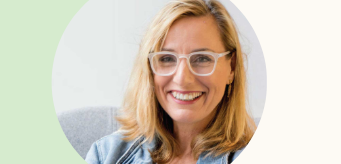 An individual wearing glasses and smiling.