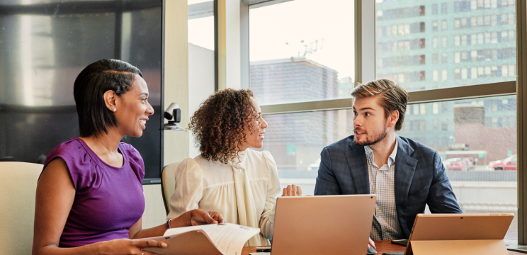 Team members participating in a nonprofit leadership training session in a modern office conference room, discussing skill development.