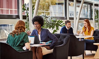 Two women discussing information on a laptop