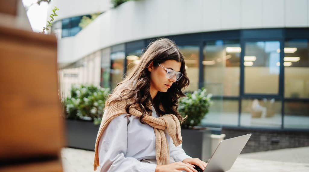 A professional working on a laptop outdoors