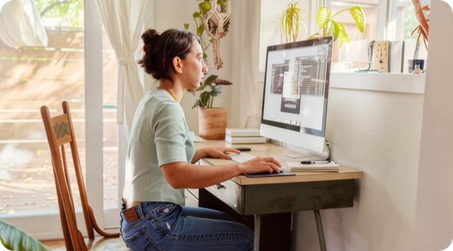 Woman working at desktop computer at home