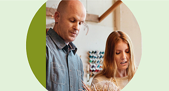 A photo of a man and a woman collaborating while looking away from the camera.