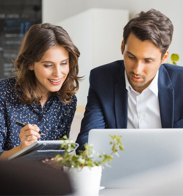 Image of two professionals sitting and working together.