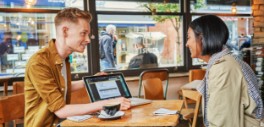 Image of a man showing something on his laptop to a woman across from him