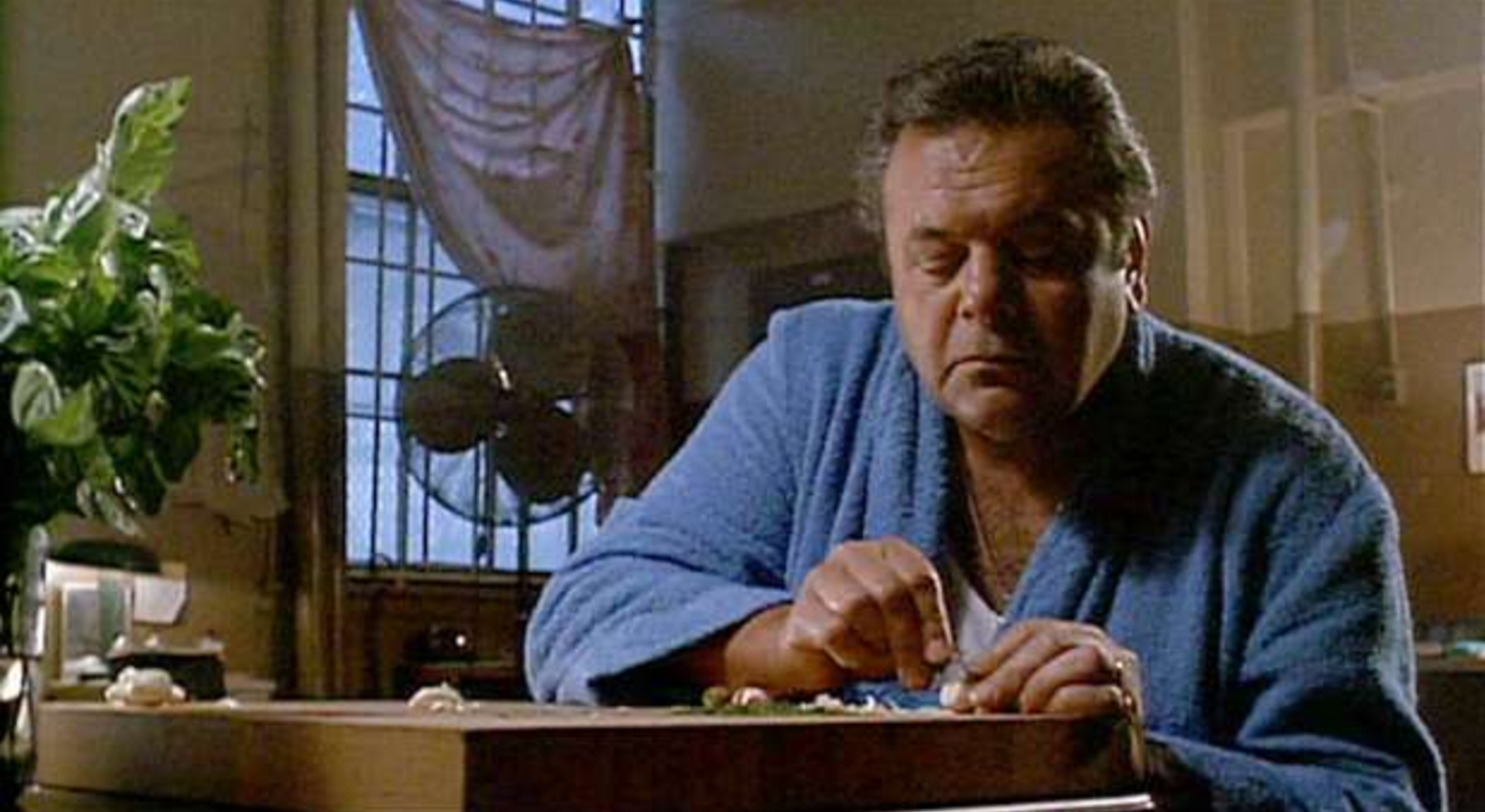 Paulie Cicero -- portrayed by Paul Sorvino in the movie Goodfellas -- thinly slices a garlic clove with razor blade while preparing a meal for his fellow wise guys in prison