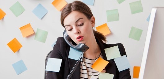 Business woman on the phone struggles with sticky notes
