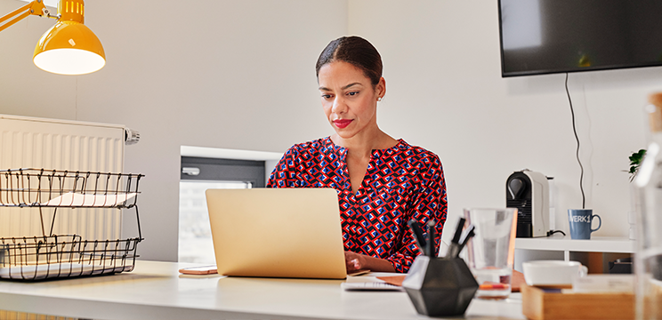 An image of a woman working intently at a laptop.