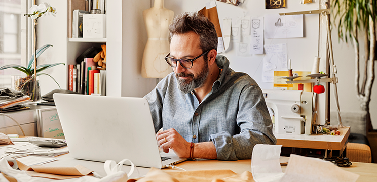 Image of a man working at a laptop.