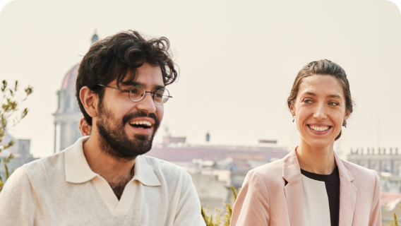 Two individuals outside and smiling together.