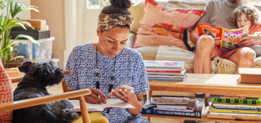 Woman working from home with family sitting on couch
