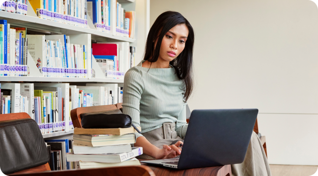 Focused student working on laptop in library