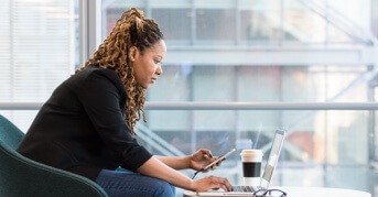 Person searching on mobile device and laptop computer
