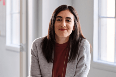 Woman in a grey cardigan smiling at the camera