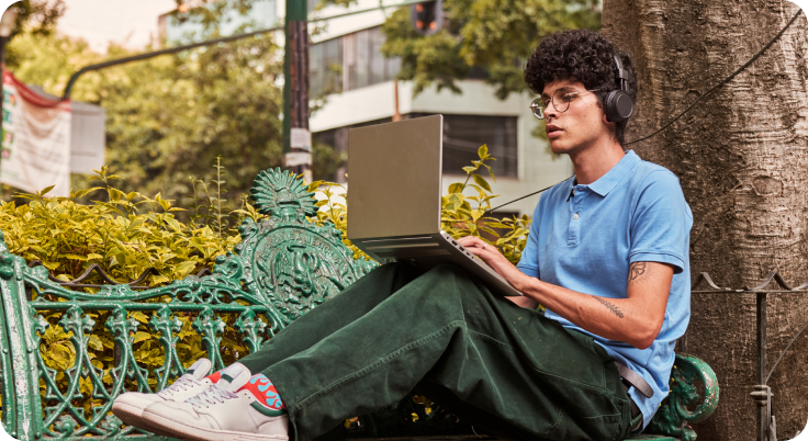 Young man working on laptop outdoors