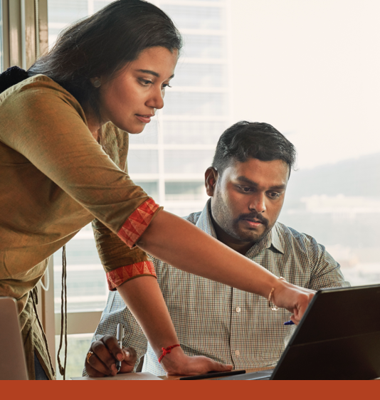 A man and woman discussing information on a laptop