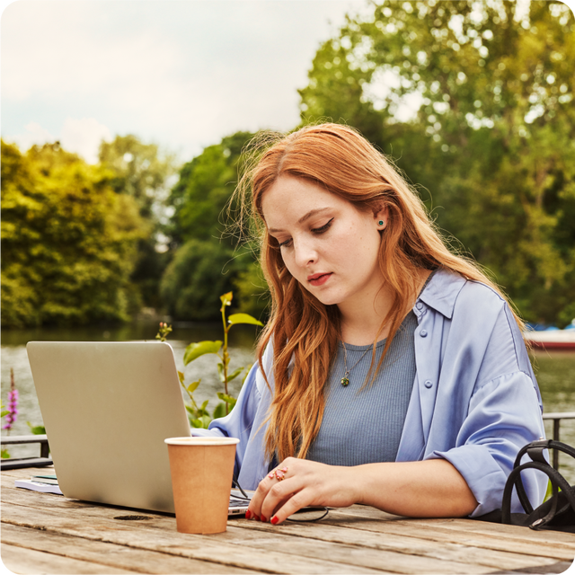 Young woman working on laptop outdoors