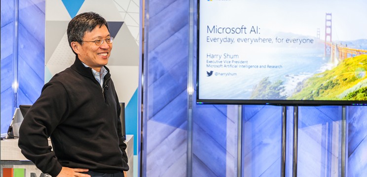 Harry Shum, ex-Executive Vice President of Microsoft Artificial Intelligence and Research presents in front of a large screen