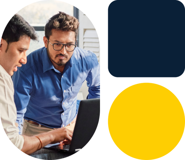 Two colleagues collaborating at laptop workstation