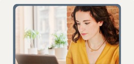 Screen showing woman wearing yellow looking at computer