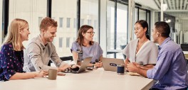 Image of people sitting at a table looking at each other