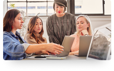 photo of several people in discussion around a laptop