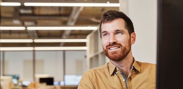 man looking up and away from computer