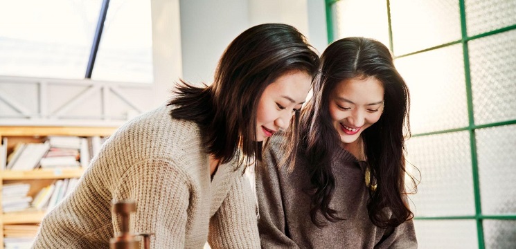 Two women standing and looking down at something