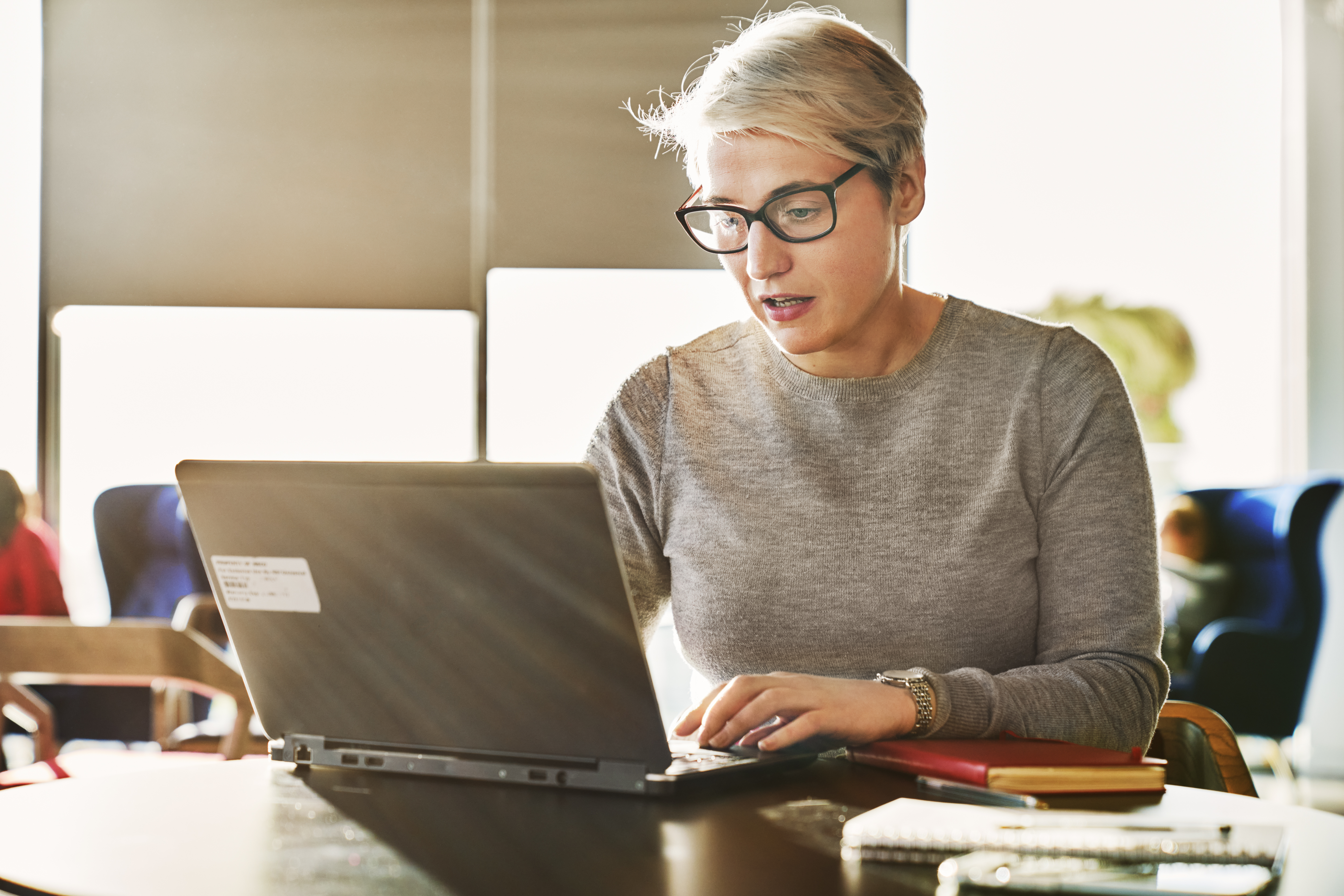 woman looking at laptop at desk setting