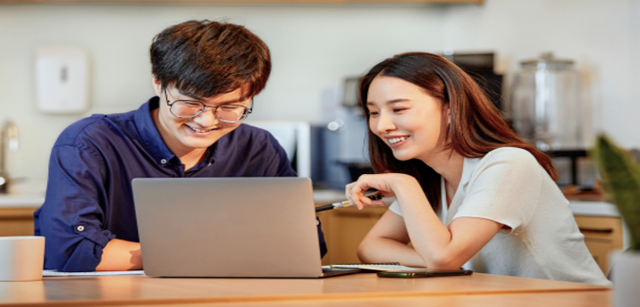 Image of two professionals collaborating on a laptop