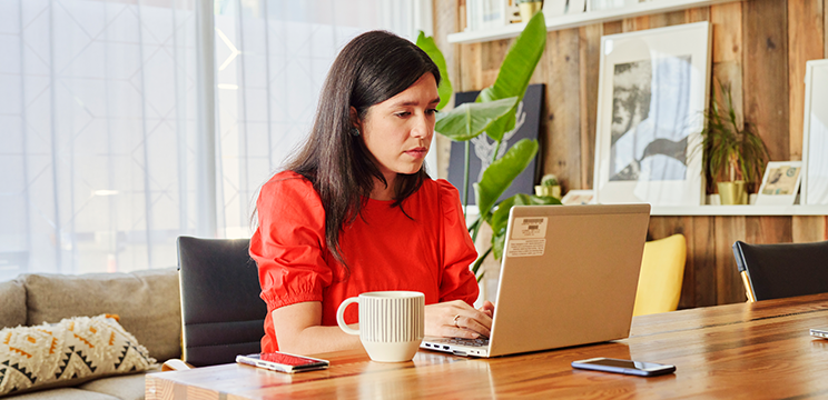 A woman works on her laptop in her home office.