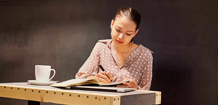 A woman writing in a notebook.