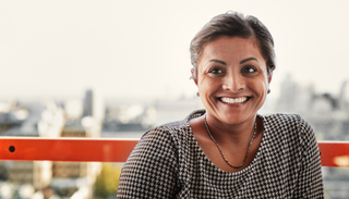Portrait d’une femme souriant à une personne en dehors du cadre.