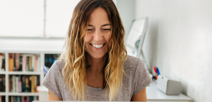 person smiling while checking her computer