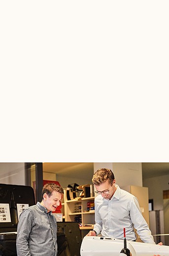 Photograph of two men looking at a tool