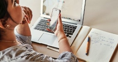 Women looking at phone and laptop