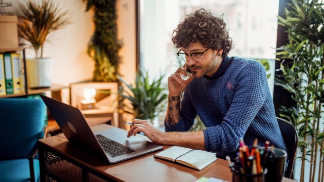 A man works at a table in his home.