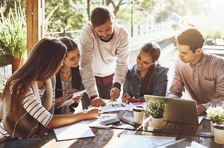 An image of a smiling team working together at a table.