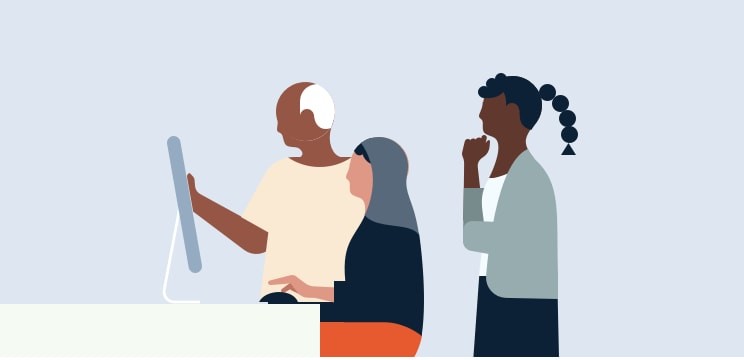 Three colleagues discuss something on the screen in front of them