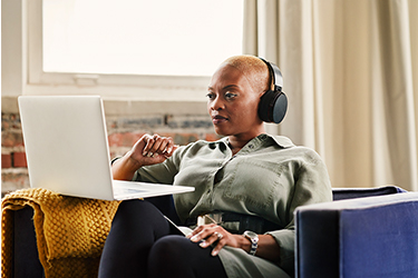 Business woman sits confidently looking at laptop