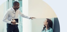 Standing man speaking with a sitting woman