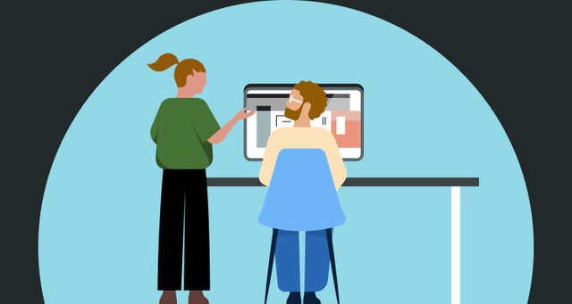 Hero image of two professionals having a discussion in front of a desktop computer.