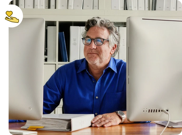 An individual at their computer with two monitors.
