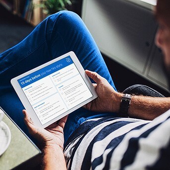 Man holding iPad with onboarding checklist on the screen