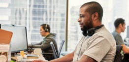 Image of man with headphones sitting at computer