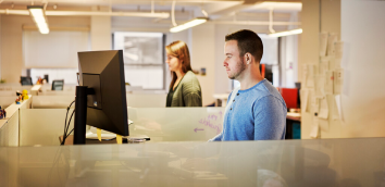Des professionnels dans un bureau travaillant sur des ordinateurs de bureau.