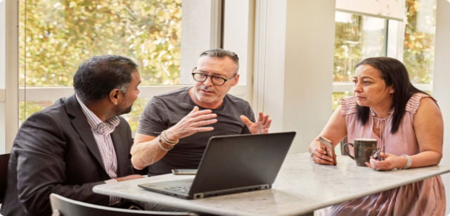 three people in a meeting at an office